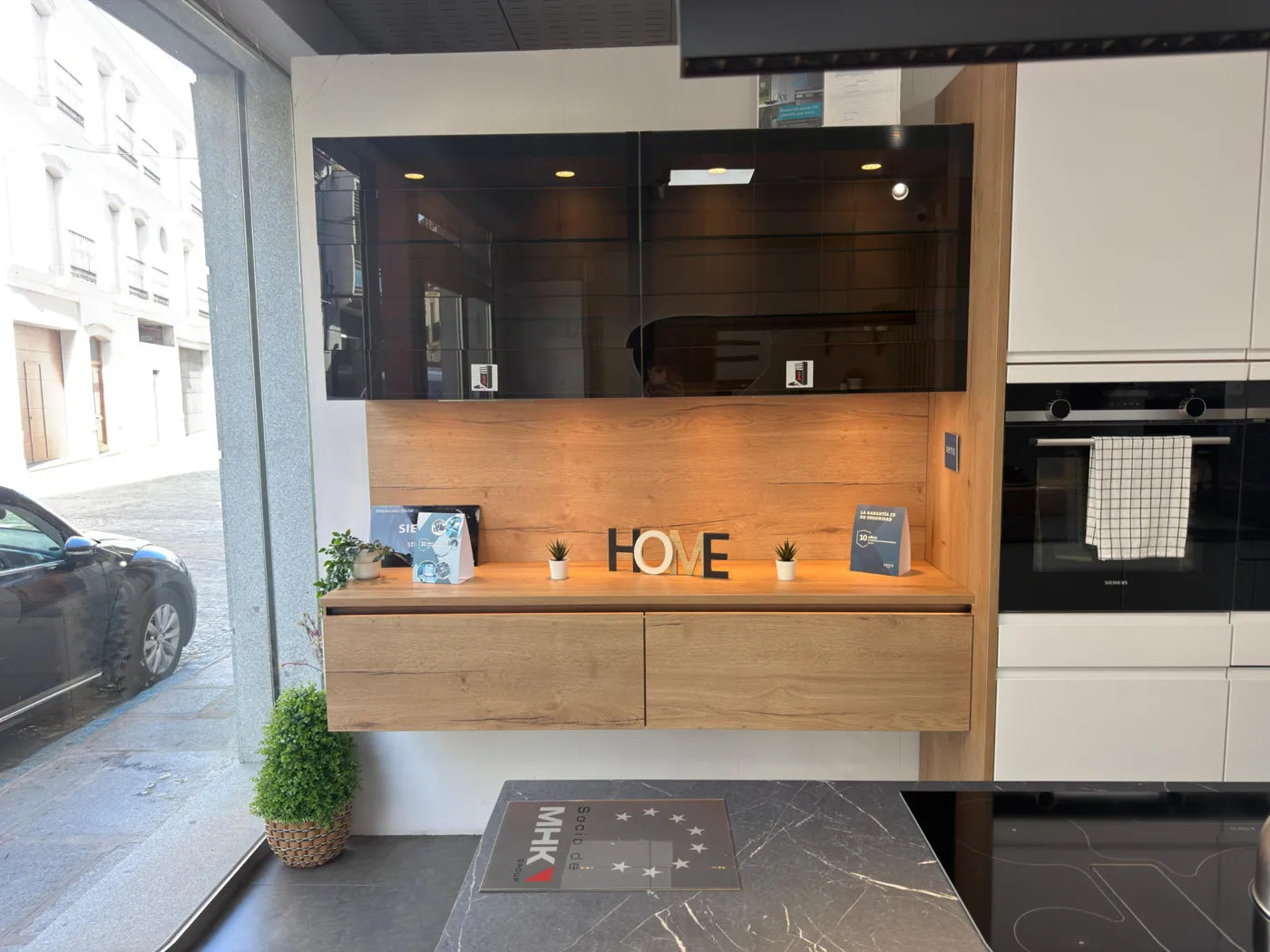 Vista real de los muebles de madera y la vitrina de la cocina con isla