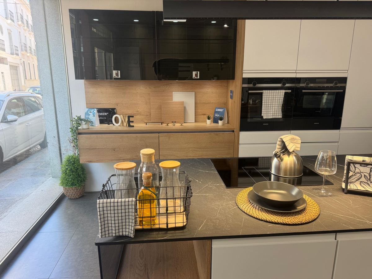 Fotografía real de nuestra cocina con isla: vitrinas, muebles de madera y electrodomésticos en columna